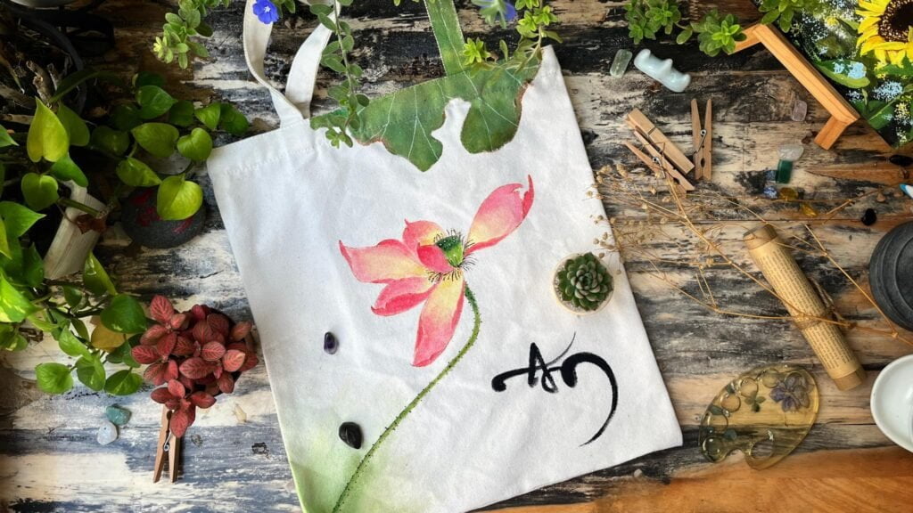 Tranh hoa sen với chữ An trên túi Canva